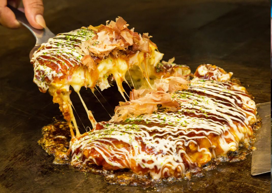 Il saporito pancake chiamato okonomiyaki cotto sulla piastra