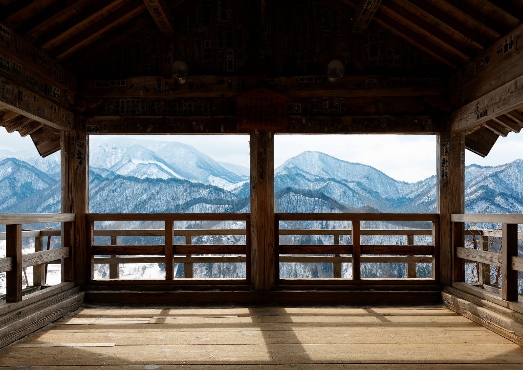 Una vista panoramica sulle montagne invernali innevate dall'interno della Godaido Hall.