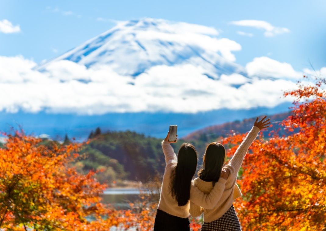 Amici che scattano foto, in viaggio insieme verso il monte Fuji.