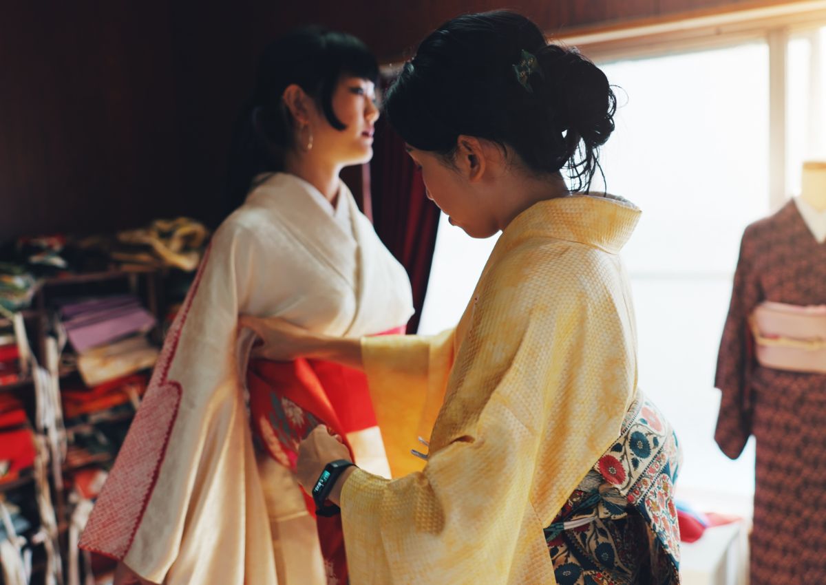Donna che aiuta un’altra donna a indossare un kimono