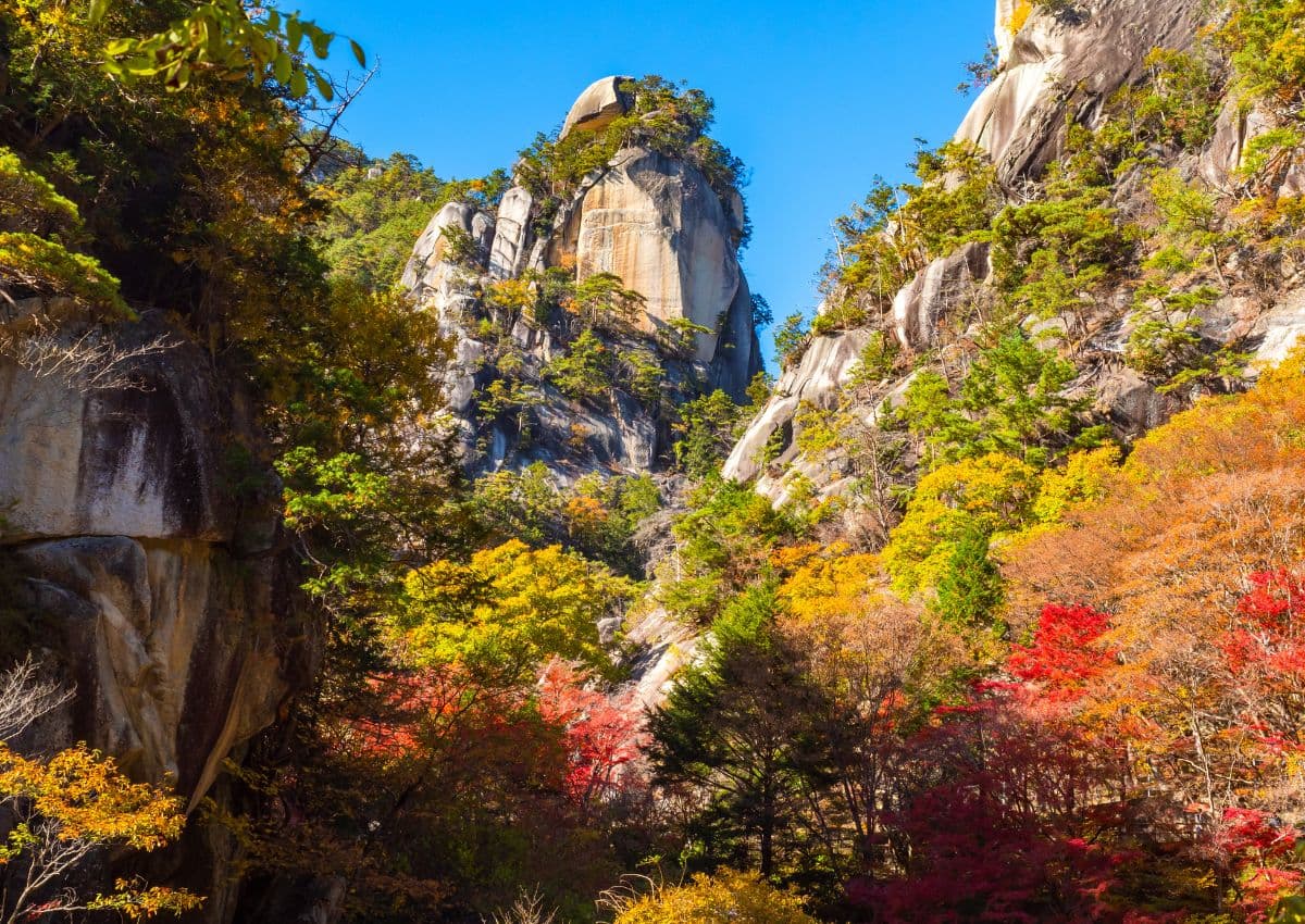 Sentiero tra grandi formazioni rocciose nella gola di Shosenkyo in autunno