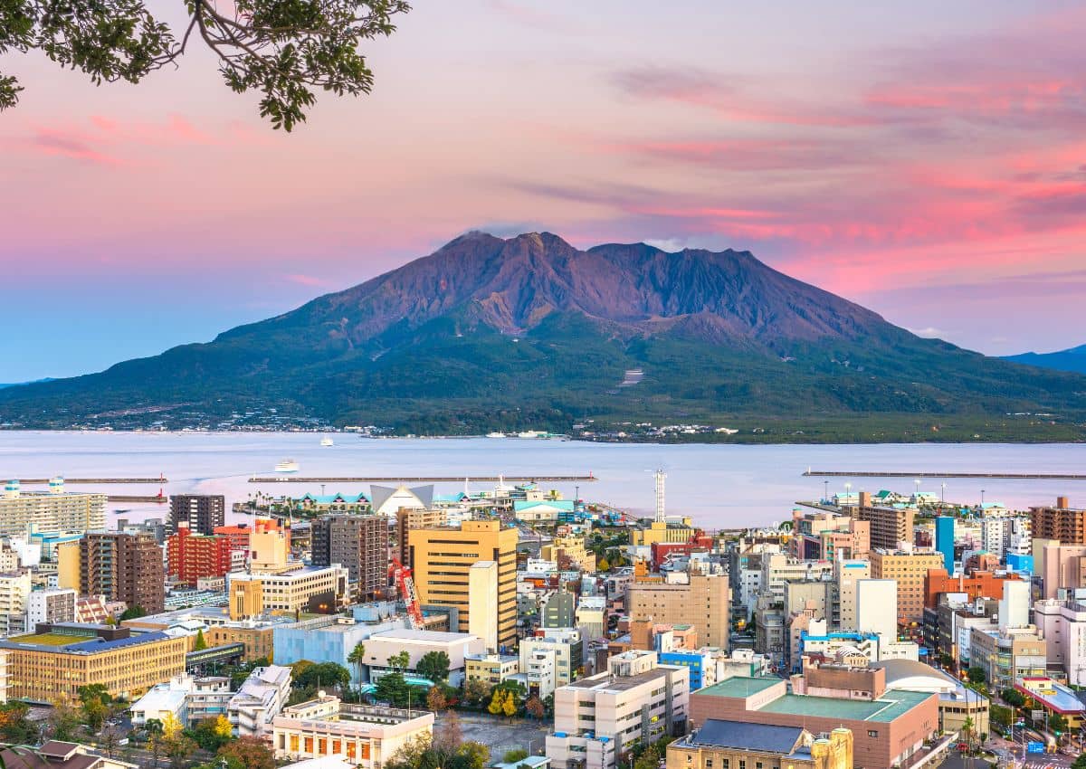 Il profilo urbano di Kagoshima con il vulcano Sakurajima al tramonto