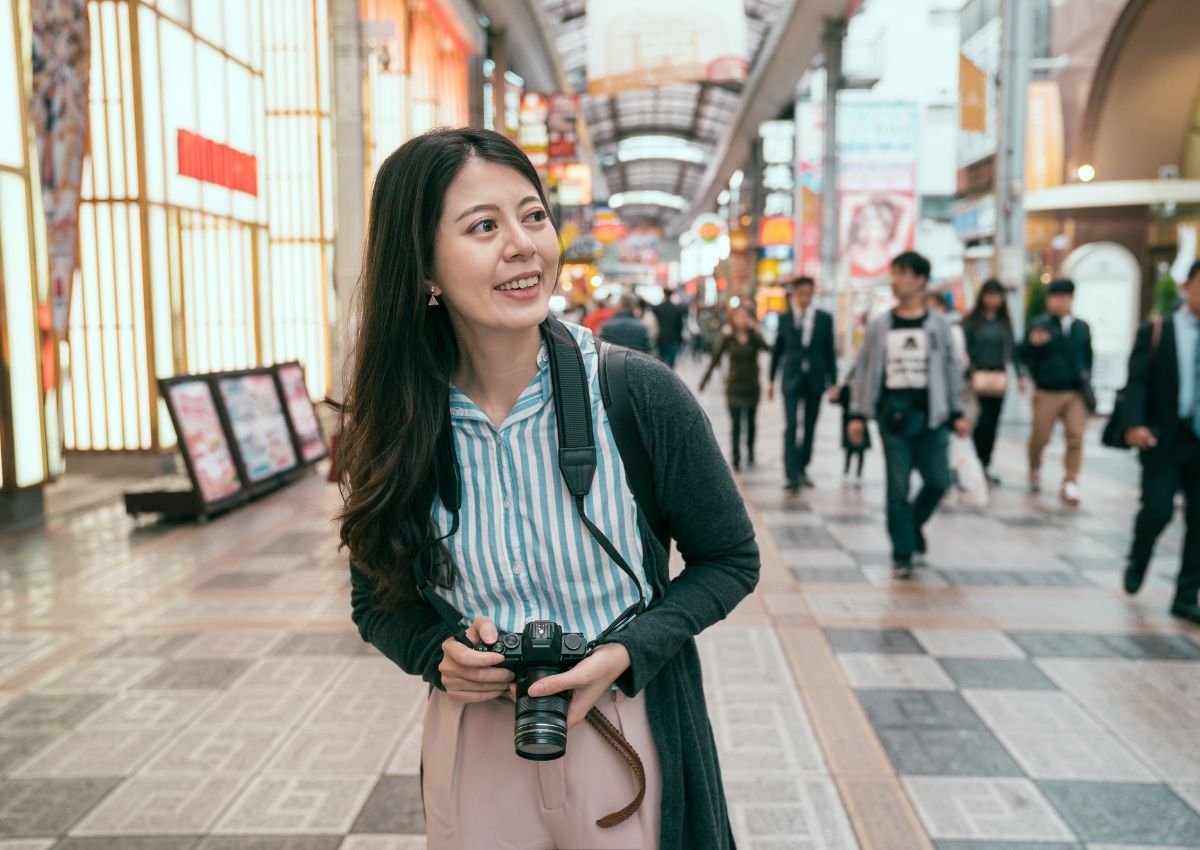 Donna che esplora la via dello shopping Tenjinbashisuji, Osaka, Giappone