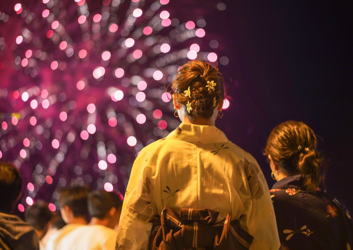 Donna in yukata durante un festival di fuochi d’artificio in Giappone