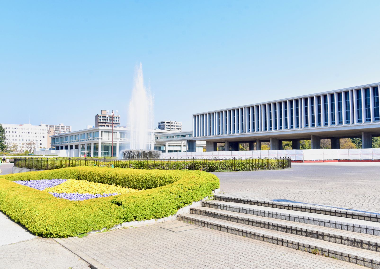 Museo della Pace di Hiroshima, un moderno edificio in cemento e vetro con il cielo blu che si riflette in una piscina antistante