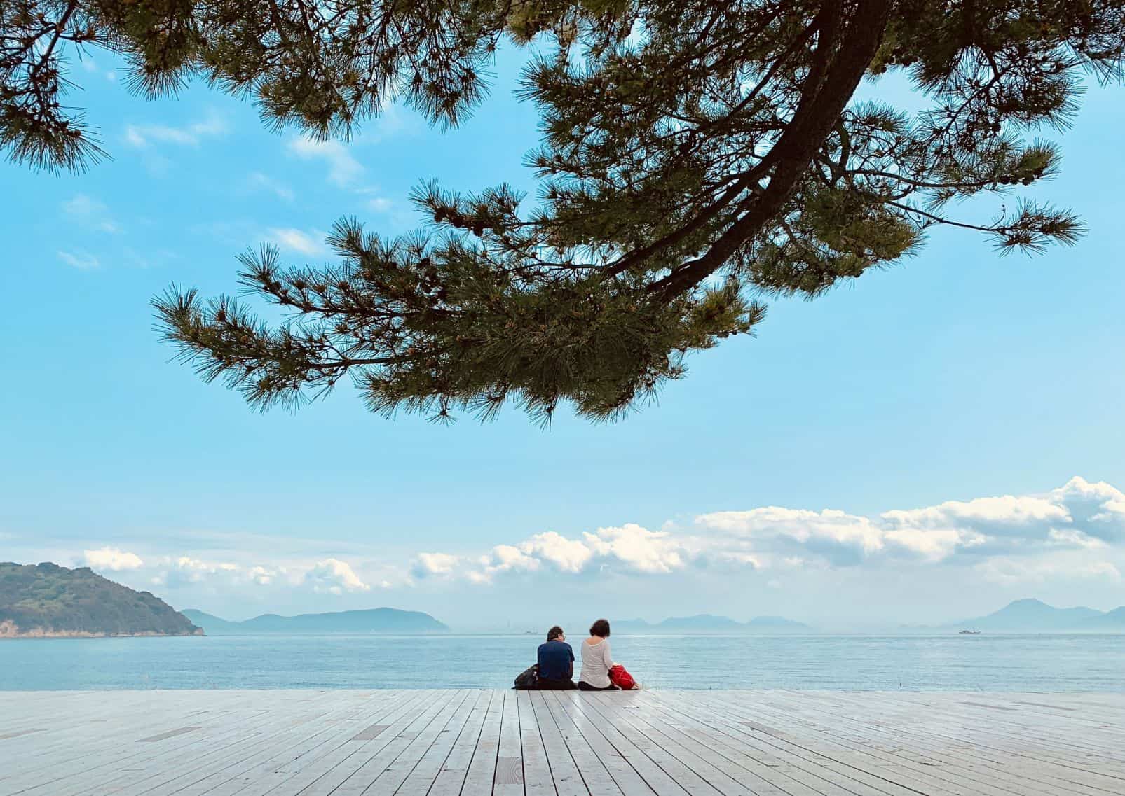 Persone sedute sulla spiaggia soleggiata di Naoshima
