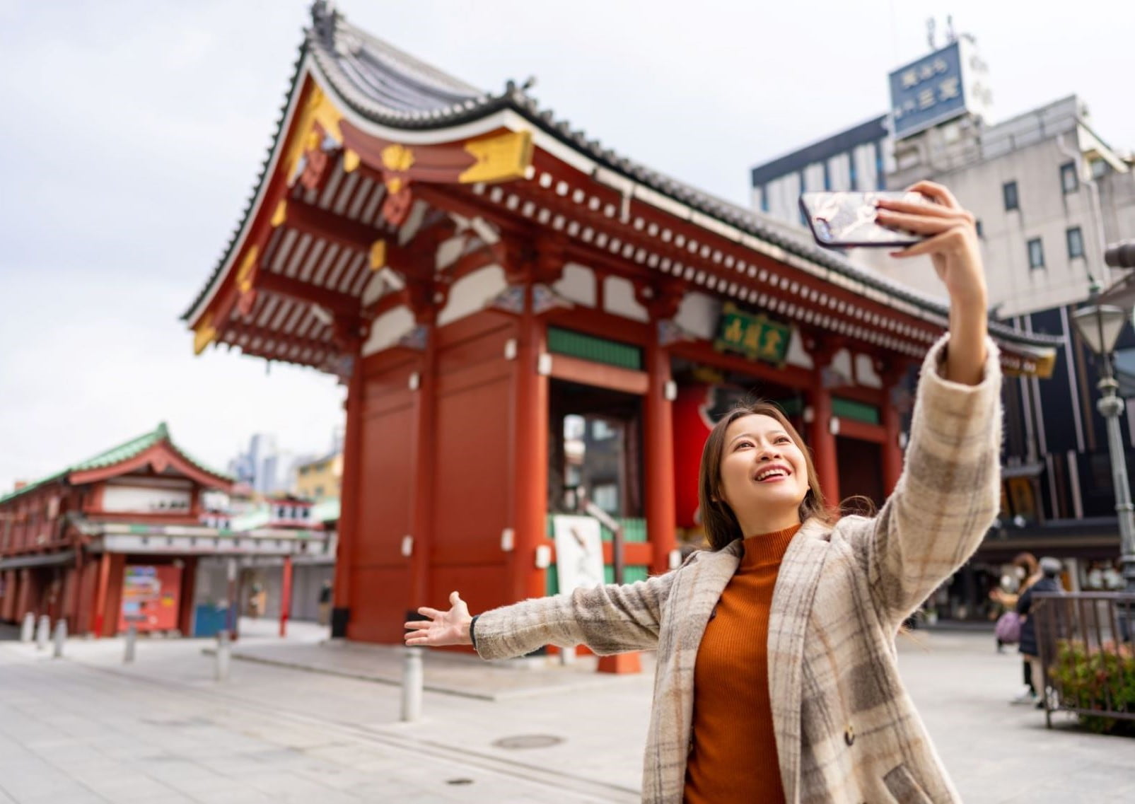 Ragazza scatta un selfie davanti al Tempio Sensoji , Asakusa, Tokyo, Giappone