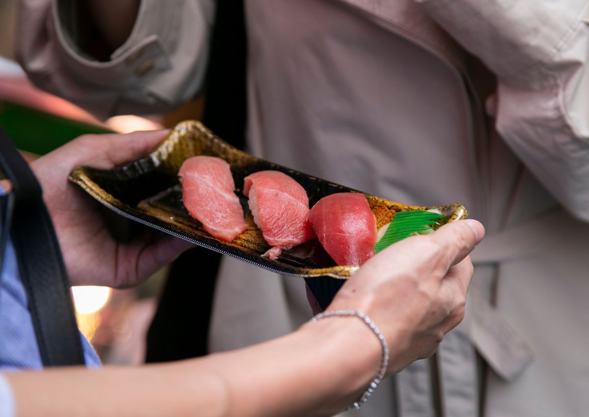 Una donna con del sushi fresco al Tsukiji Fish Market, Tokyo