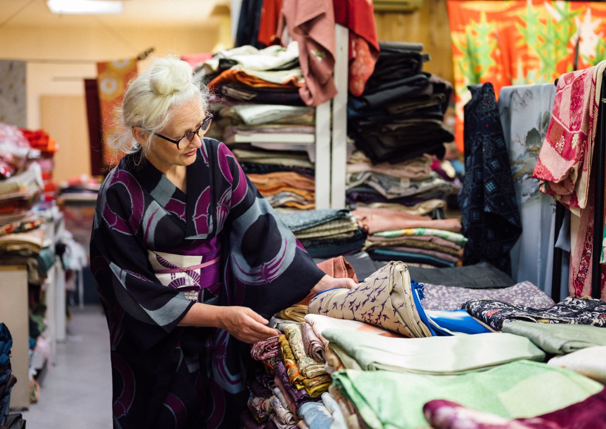 Donna osserva tessuti in un negozio vintage di kimono
