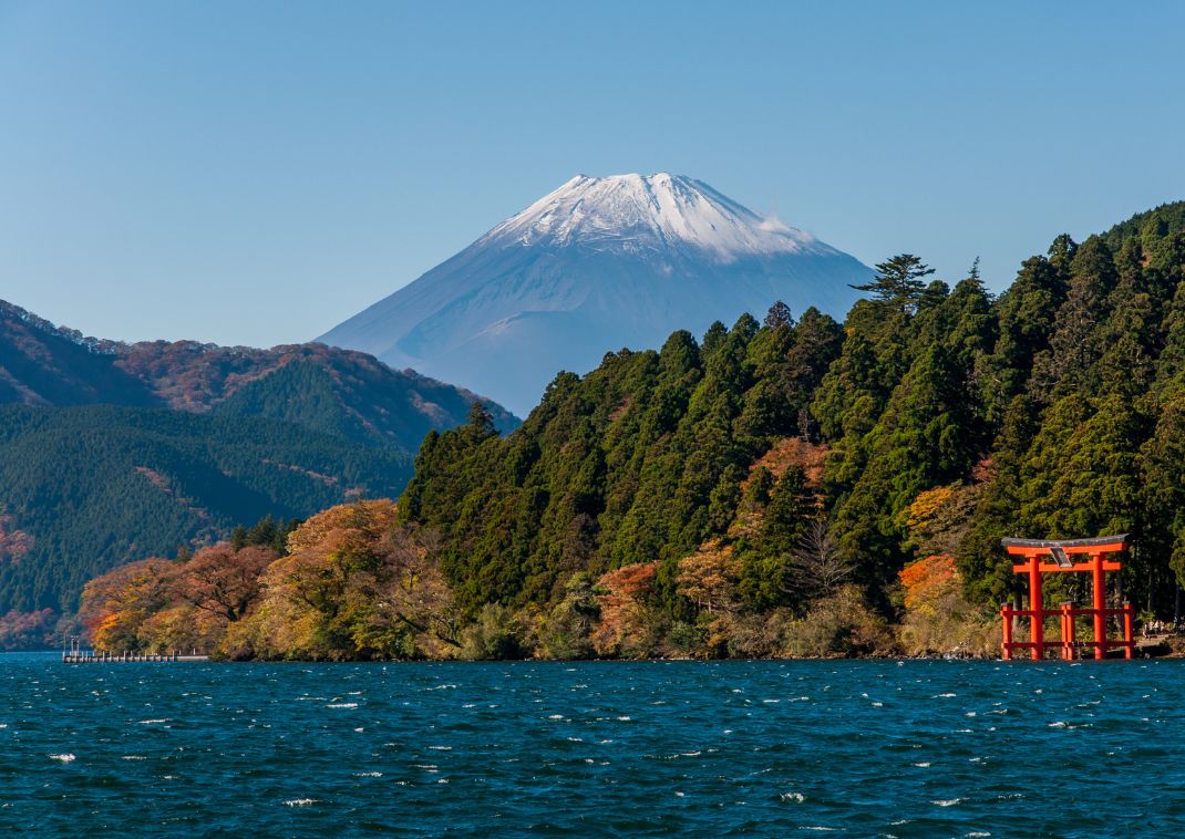 Monte Fuji e cancello Torii rosso su un lago sotto un cielo azzurro e limpido