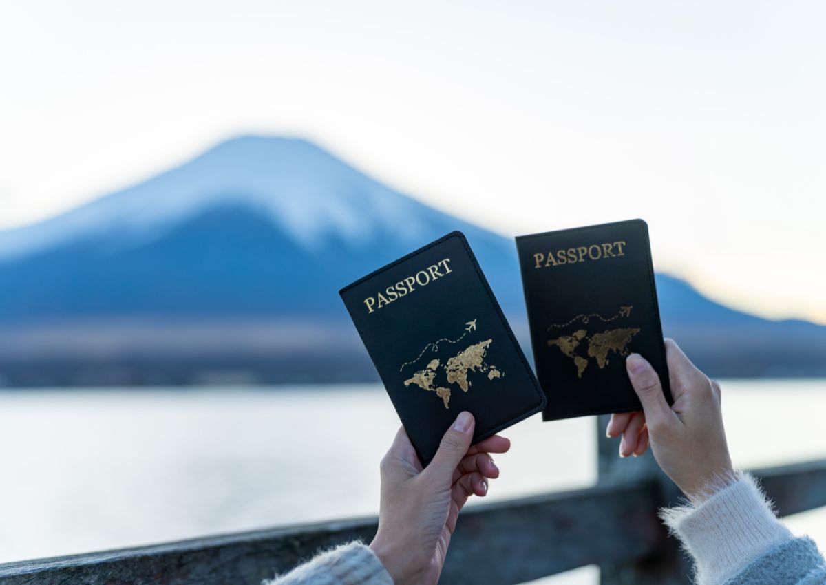 Ragazza tenendo un passaporto in fronte del Monte Fuji