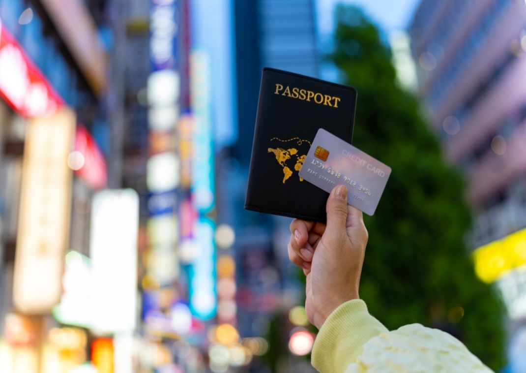 Mano di una donna con un passaporto e una carta di credito a Tokyo