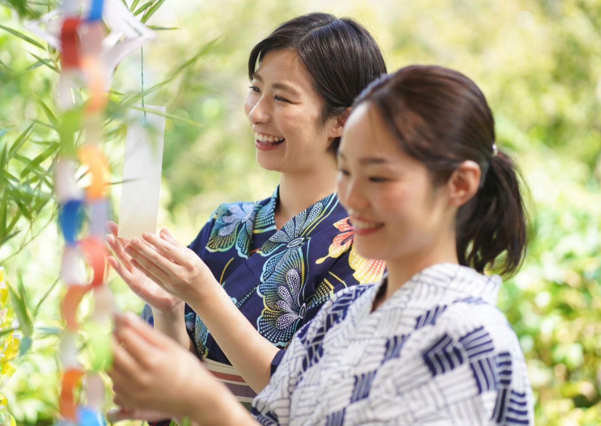 Donne giapponesi che scrivono desideri per il Tanabata
