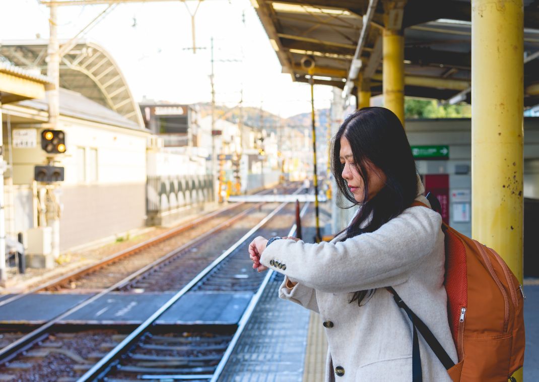 Donna che guarda l'orologio in una stazione ferroviaria in Giappone