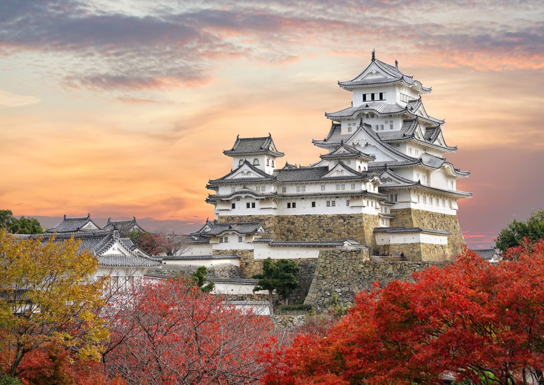 Castello di Himeji e foglie rosse d'acero alla luce del tramonto e cielo crepuscolare nella città di Himeji, prefettura di Hyogo, Giappone