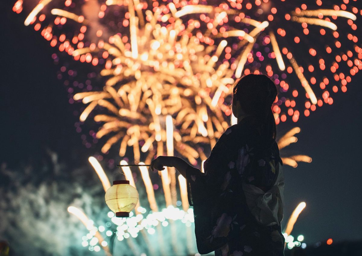 Una donna in yukata ad un festival di fuochi d’artificio a Tokyo