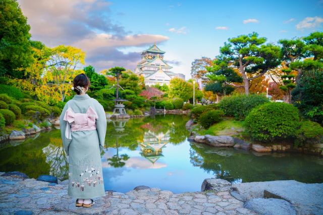 Donna in kimono con il castello di Osaka