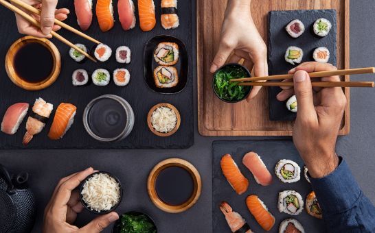 Assortimento di sushi, tra cui nigiri, sashimi e involtini, da condividere e mangiare con le bacchette.