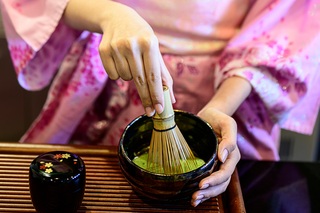 Signora in kimono che prepara il tè verde giapponese