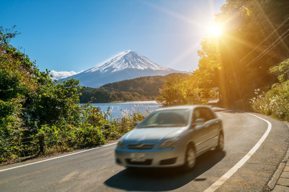 Auto che guida vicino al monte Fuji, in Giappone, con sfocatura del movimento che mostra un rapido movimento su una strada statale presso il lago Kawaguchiko