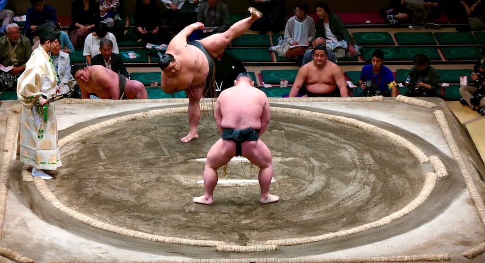 Lottatori di sumo giapponesi che si preparano per un incontro sul ring, indossando il tradizionale mawashi