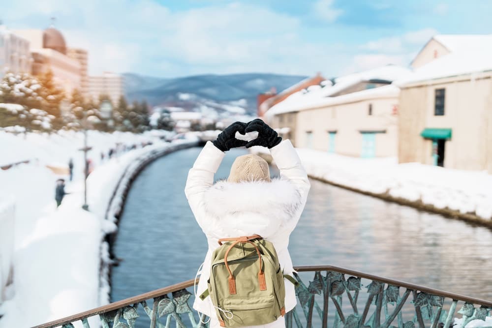 Turisti in visita lungo il canale innevato di Otaru a Hokkaido, in Giappone, per godersi la stagione invernale