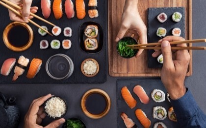 Assortimento di sushi, tra cui nigiri, sashimi e involtini, da condividere e mangiare con le bacchette.