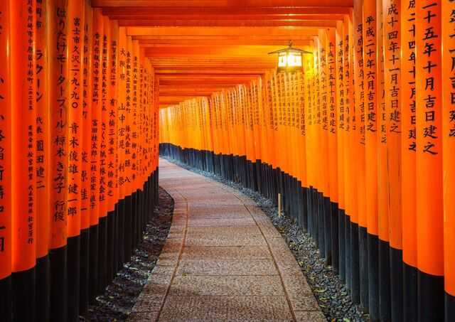 Tradizionale torii rosso con iscrizioni nere al santuario Fushimi Inari, Kyoto, Giappone 