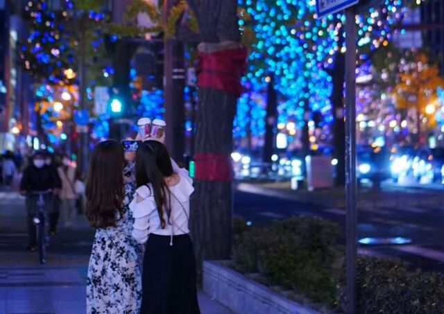 Due donne fanno un selfie sotto le luminarie natalizie a Osaka, Giappone