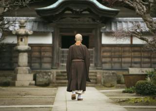 Un monaco nel cortile di un monastero a Kamakura