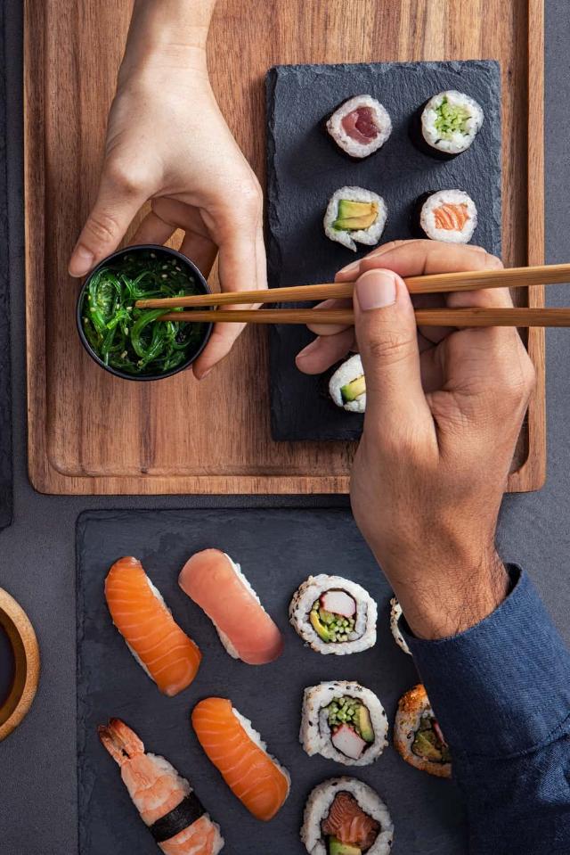 Assortimento di sushi, tra cui nigiri, sashimi e involtini, da condividere e mangiare con le bacchette.